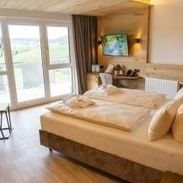 Hotelzimmer mit Doppelbett und Blick zum Balkon