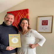 Inhaber mit Award Plakette