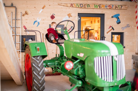 Kind auf Spieltraktor