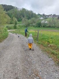 Kind mit großem Hammer auf dem Feldweg zum Zaun reparieren