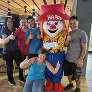 Mitarbeiter und Clown Happy mit dem Preis Top-Unternehmen 2026