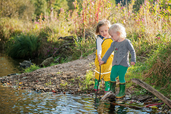 Kinderbetreuung im Familienhotel Kinder in Matschklamotten am Bach