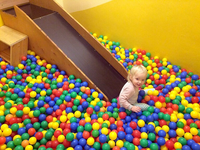 Kind sitzt im Bällebad
