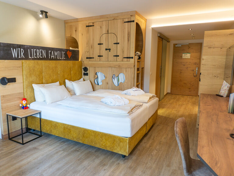 Doppelbett Hotelzimmer mit Rutsche hinter dem Bett und Hochbett für die Kinder am Elternbett
