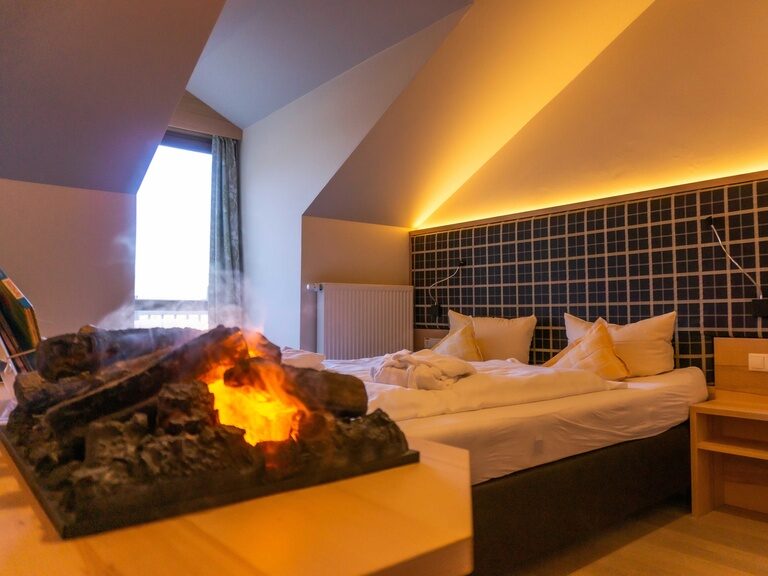 Doppelbett Hotelzimmer mit Deko Kamin
