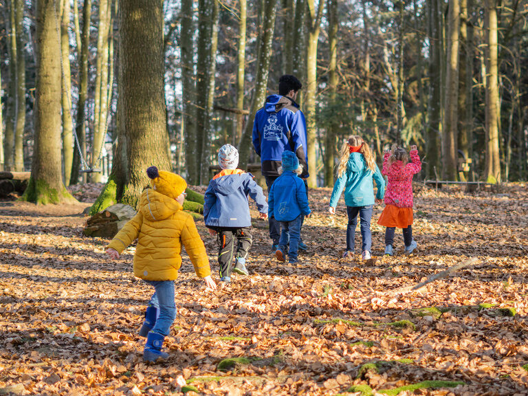 Kinderbetreuer mit Kindern im Wald