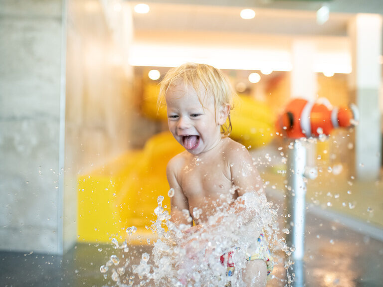 Kind spritzt mit Wasser