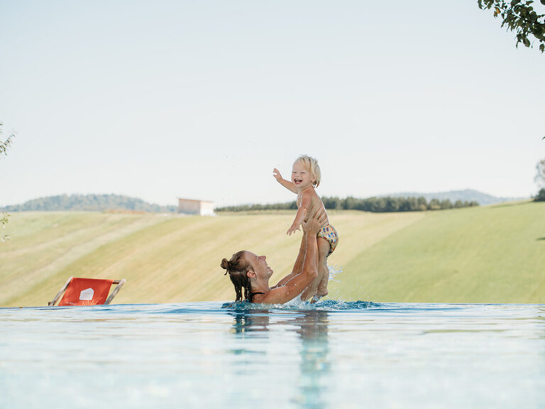 Mutter hebt Kind aus dem Wasser