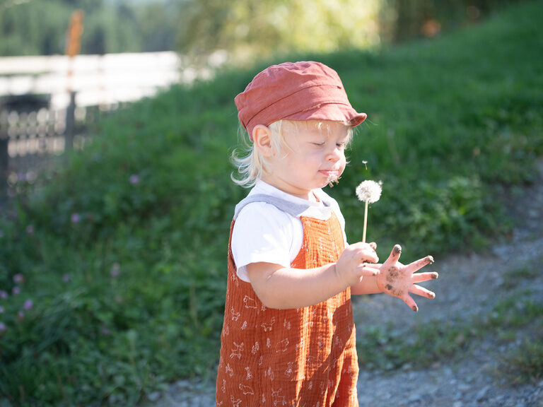 Kleinkind mit Pusteblume