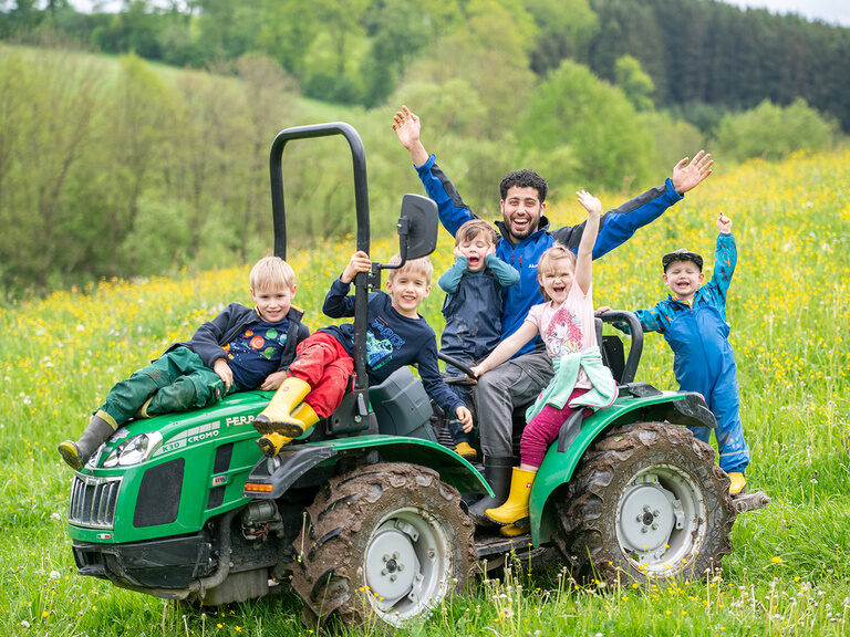 Kinder und Kinderbetreur jubeln auf Traktor