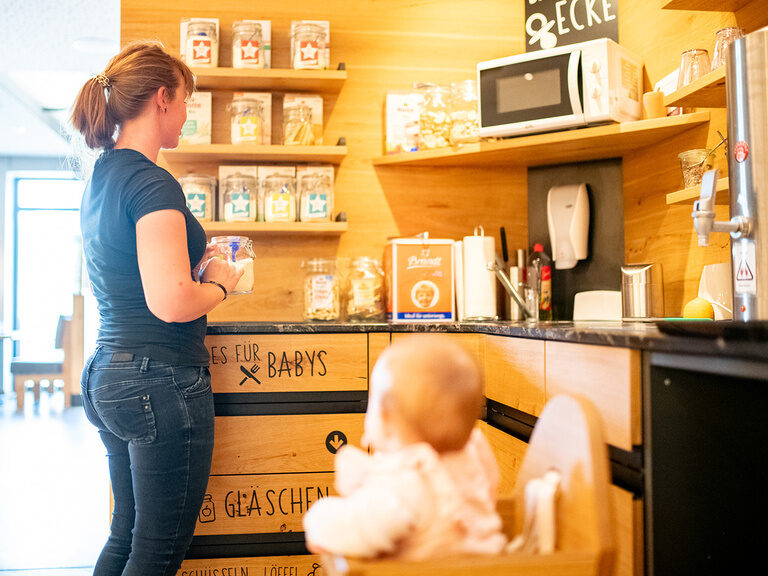 Frau und Baby an der Baby-Brei Station