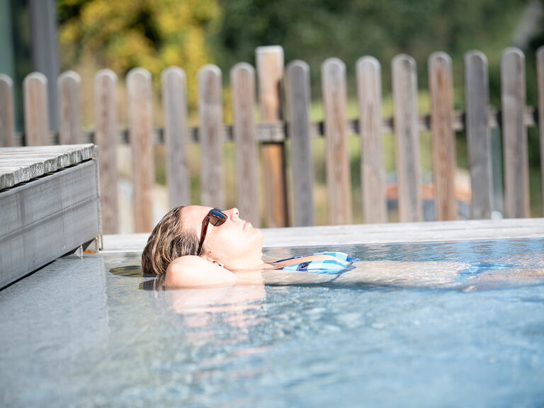 Frau entspannt im Außenpool