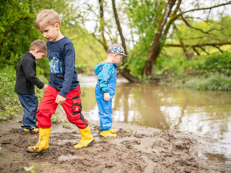3 Jungs am Bach mit Matschkleidung