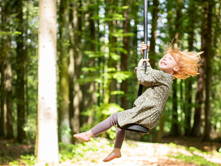 Kind auf Seilfähre im Wald
