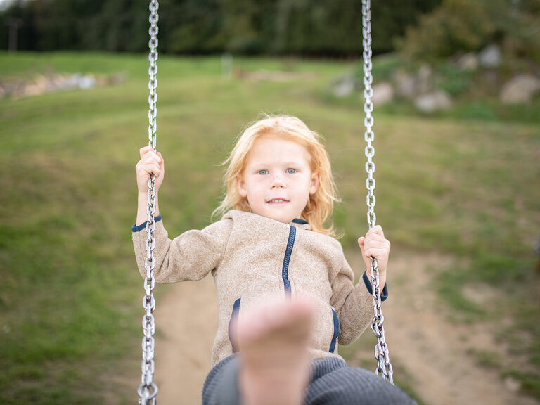 Kind schaukelt Barfuß