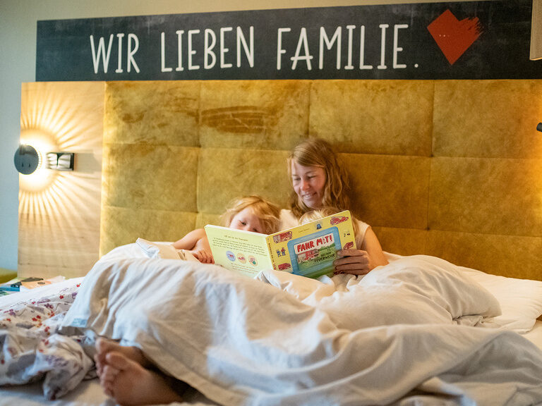 Mama und Kinder kuscheln im Familienbett