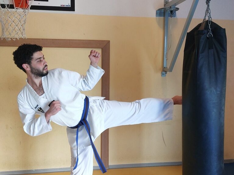 Mann tritt gegen Sandsack