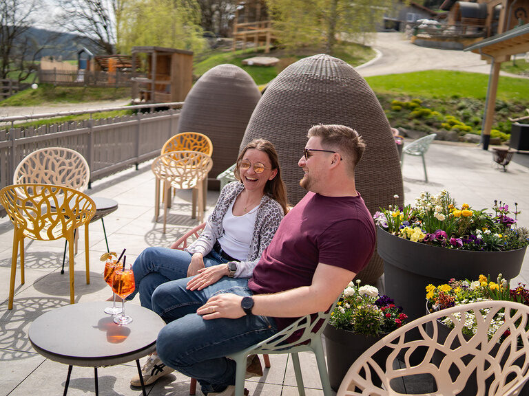 Mann und Frau sitzen auf der Terrasse mit einem Glas Aperol