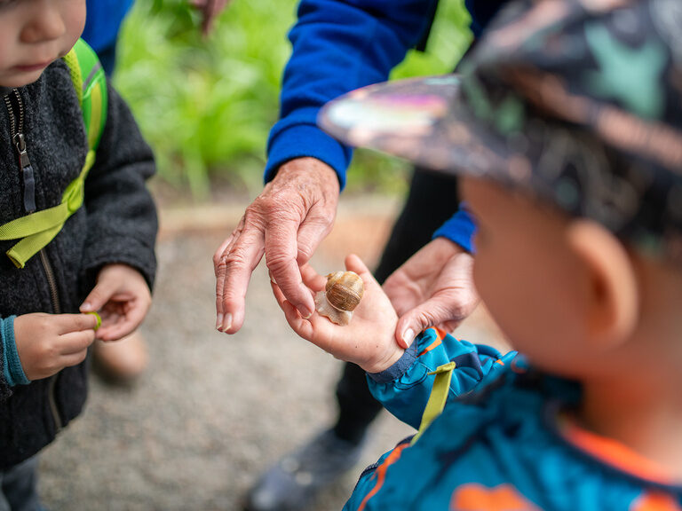 Kinder mit Schnecke in der Hand