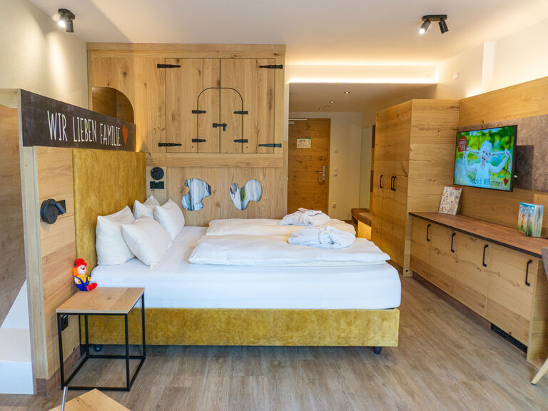 Doppelbett Hotelzimmer mit Rutsche hinter dem Bett und Hochbett für die Kinder am Elternbett