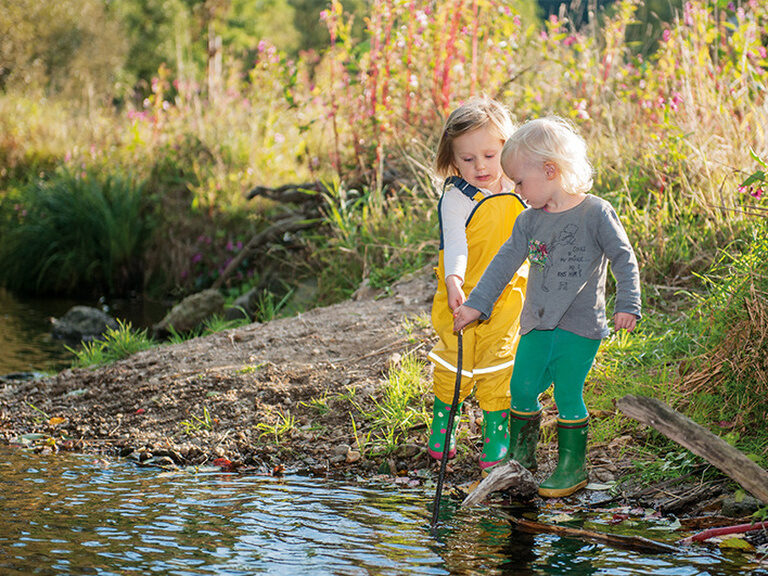 Kinderbetreuung im Familienhotel Kinder in Matschklamotten am Bach