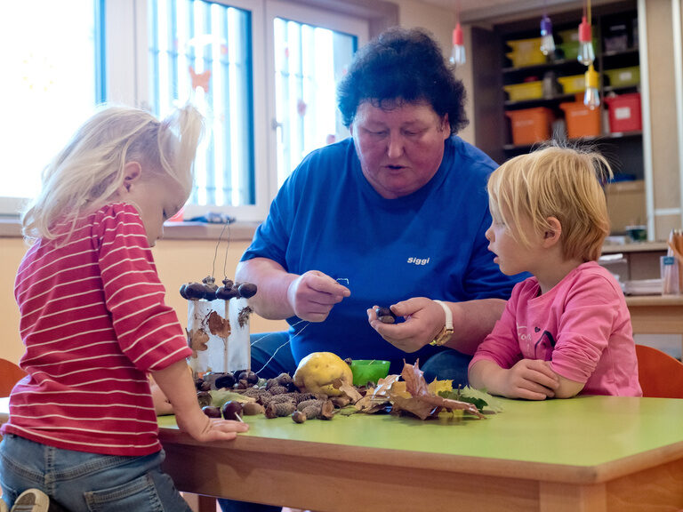 Kinderbetreuerin bastelte mit 2 Kindern mit Naturmaterialien
